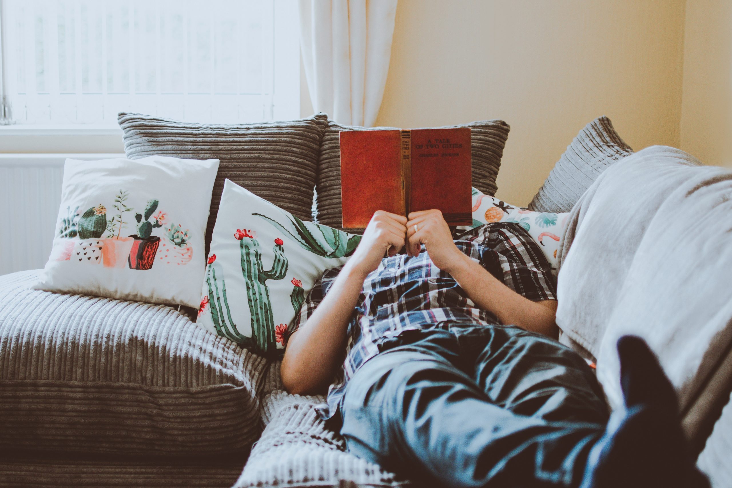 person laying on sofa while reading book 1471991 scaled